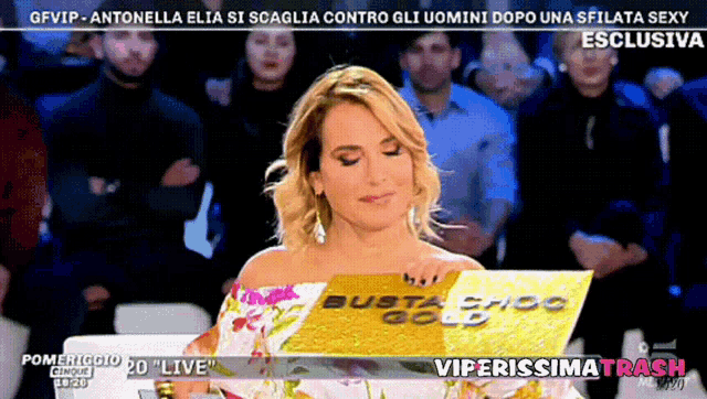 a woman holding a piece of paper with busta choc gold on it