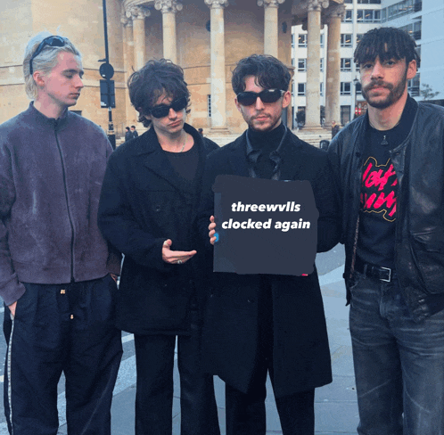a group of men are holding a sign that says threewvils clocked again