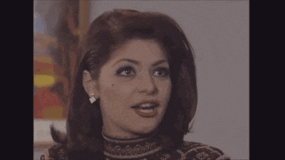 a close up of a woman 's face with her mouth open and earrings .