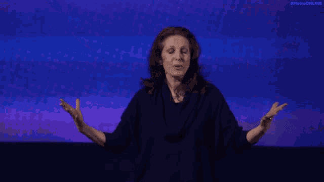 a woman with her arms outstretched is wearing a black shirt