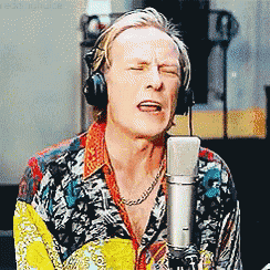 a man singing into a microphone with headphones on