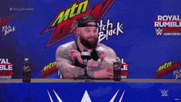 a man is standing in front of a wall that says royal rumble