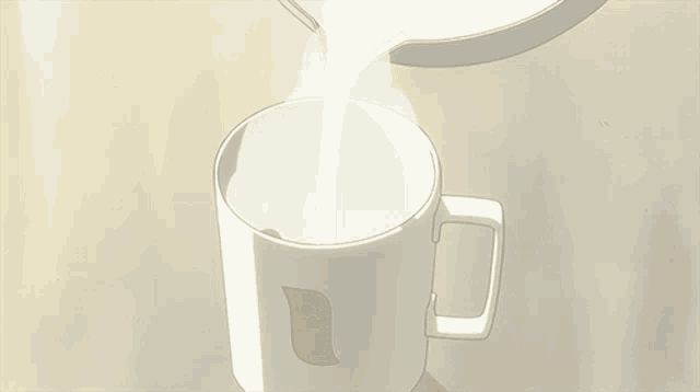 a cup of milk is being poured into a mug with a bird on it