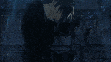 a man in a suit stands in a dark room