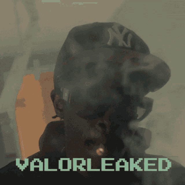 a man wearing a ny hat is smoking a cigarette with the words valorleaked behind him