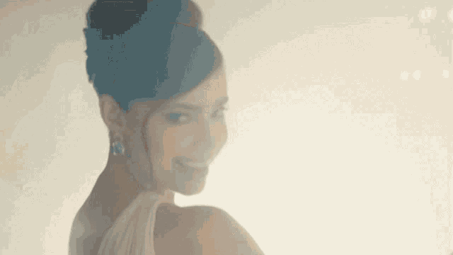 a woman in a white dress is smiling at the camera .