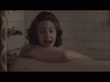 a woman with a tattoo on her arm is in a bathtub