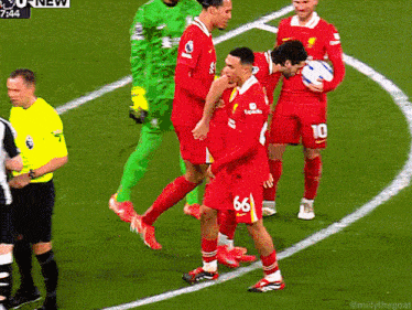 a group of soccer players are on a field and one has the number 66 on his jersey