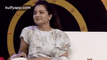 a woman is sitting on a couch with a microphone in her ear .