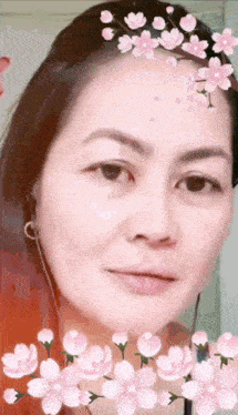 a close up of a woman 's face with flowers on her forehead