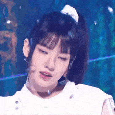 a close up of a girl 's face with a ponytail and a bow in her hair .