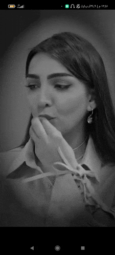 a black and white photo of a woman with her hand on her mouth