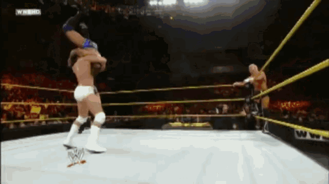 two men are wrestling in a ring with the letters w on the side