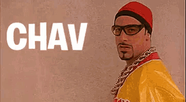 a man wearing glasses and a red hat is standing in front of a wall with the word chav .