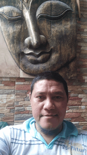 a man wearing a blue shirt that says adventure poses for a picture