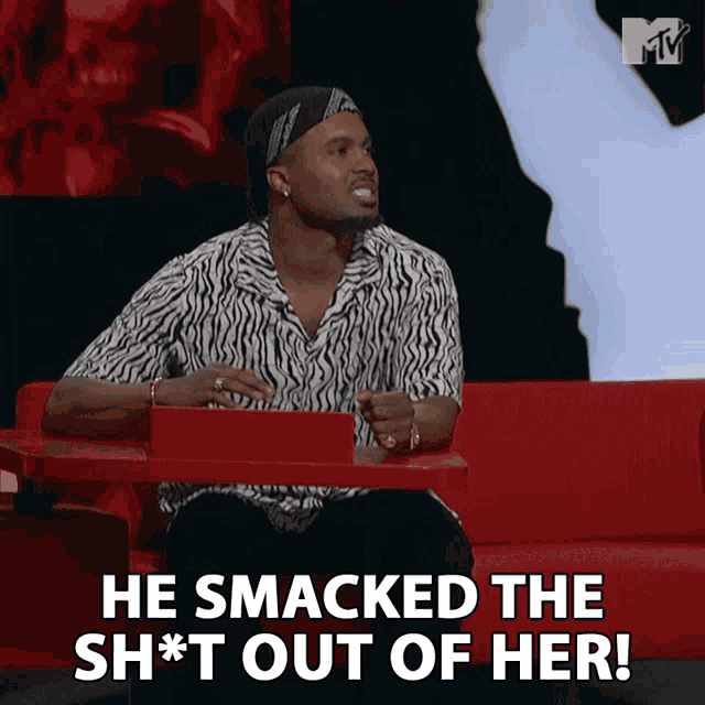 a man sitting on a red couch with the words he smacked the sh*t out of her