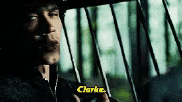 a man in a cowboy hat is holding a gun and says clarke .