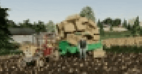 a blurry picture of a pile of hay in a field with trees in the background