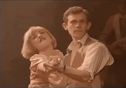 a man and a woman are dancing together and the woman is singing