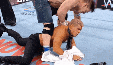 two men are wrestling in a ring with a sign that says riya seas