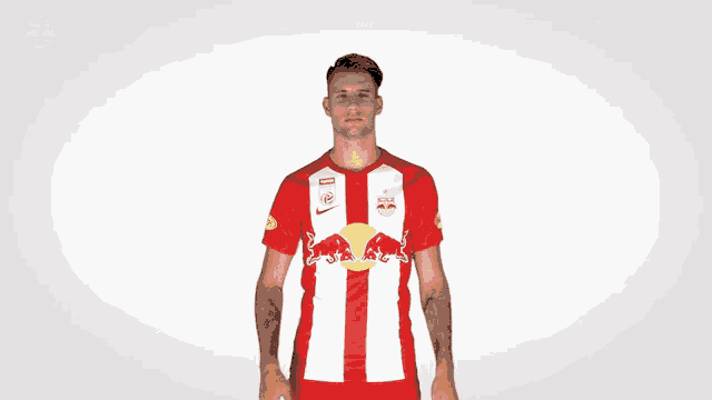 a man is wearing a red and white shirt with a red bull on it