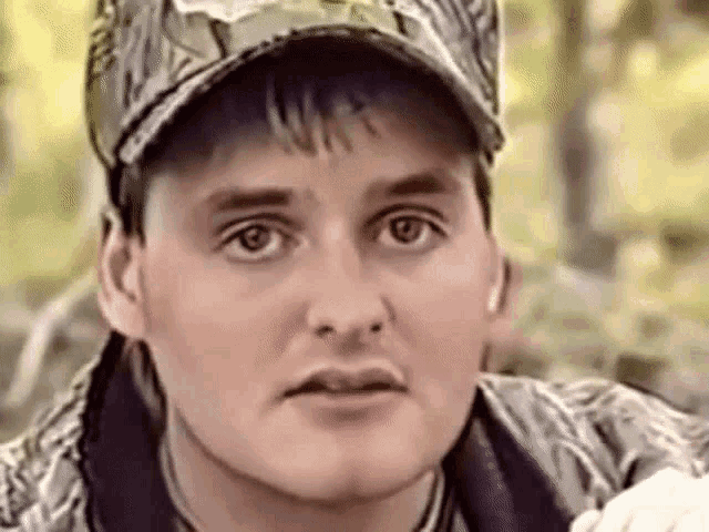 a close up of a man wearing a hat and a jacket