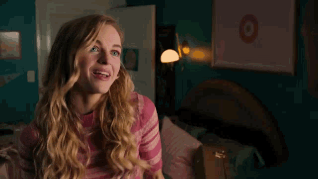 a woman in a pink sweater is smiling in front of a target poster