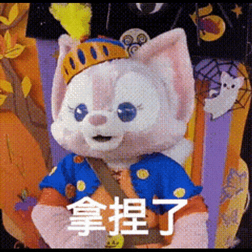 a stuffed animal with a crown on its head is wearing a blue and orange outfit .