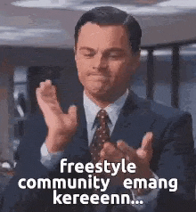a man in a suit and tie is clapping .
