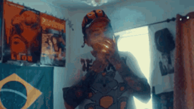 a man is smoking a cigarette in a room with posters on the wall including one for lion