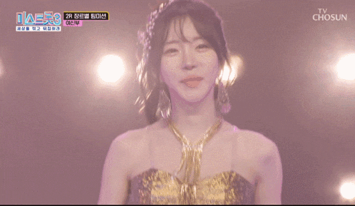 a woman in a gold dress is smiling in front of a chosun logo