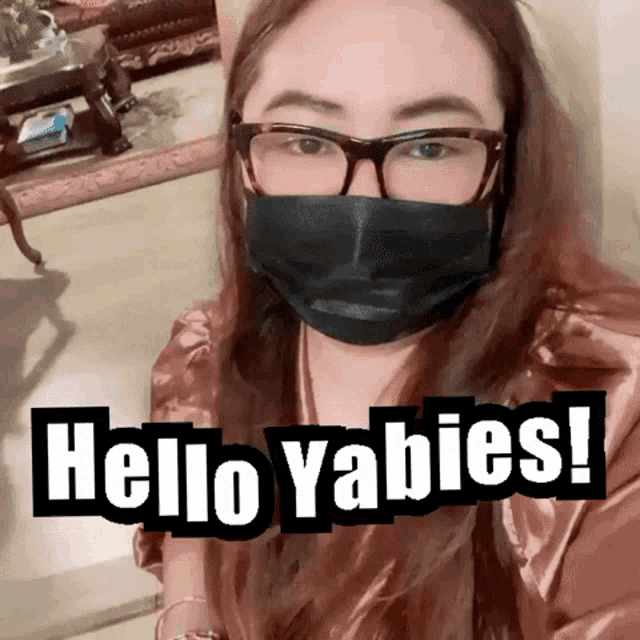 a woman wearing a face mask and glasses says hello yabies