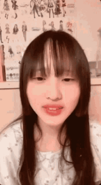 a close up of a woman 's face with long hair and bangs