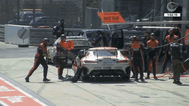a race car is parked in a pit with a sign that says race taxi