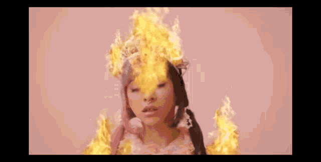 a woman with flames coming out of her head is wearing a crown .