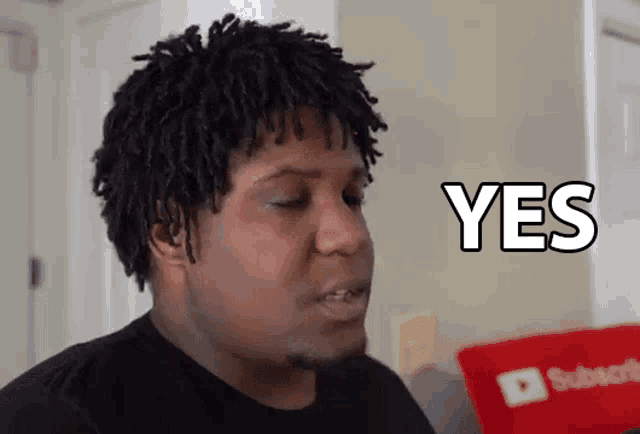a man with dreadlocks is saying yes in a room .