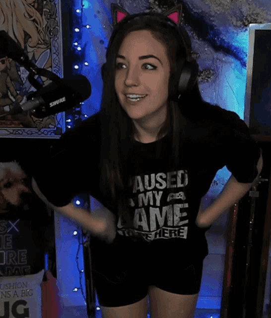 a woman wearing headphones and a shirt that says paused my love
