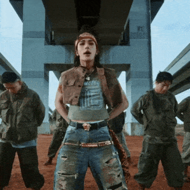 a group of people are standing under a bridge with w12 on the side