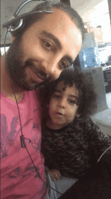 a man wearing a headset holds a child