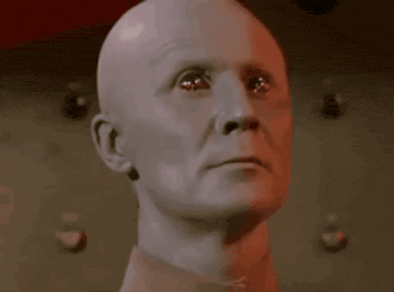 a bald man with the words " you are a robot " below him