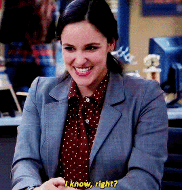 a woman in a suit and polka dot shirt is smiling and asking if she is right