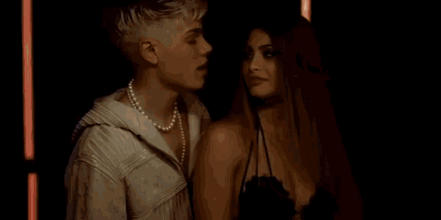 a man and a woman are kissing in a dark room .