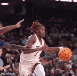 a female basketball player with the number 7 on her jersey is dribbling the ball