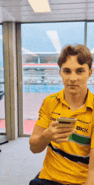 a man wearing a yellow shirt that says mclaren on it