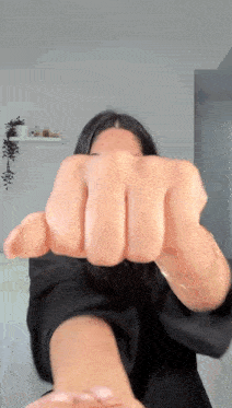 a woman is making a fist with her fingers .