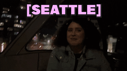 a woman sitting in a car with the words seattle written above her