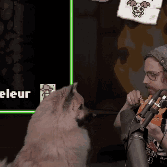 a man and a dog are sitting in front of a screen that says " eleur "
