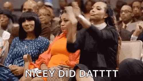 a group of women are sitting in a row in a church applauding .