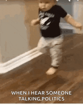 a baby is walking across a wooden floor while holding a roll of toilet paper .