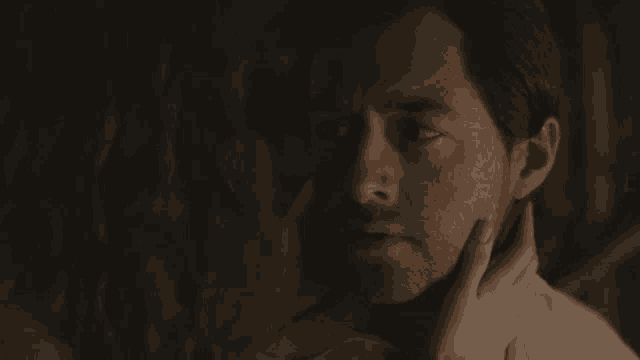 a woman touching a man 's face with her hand